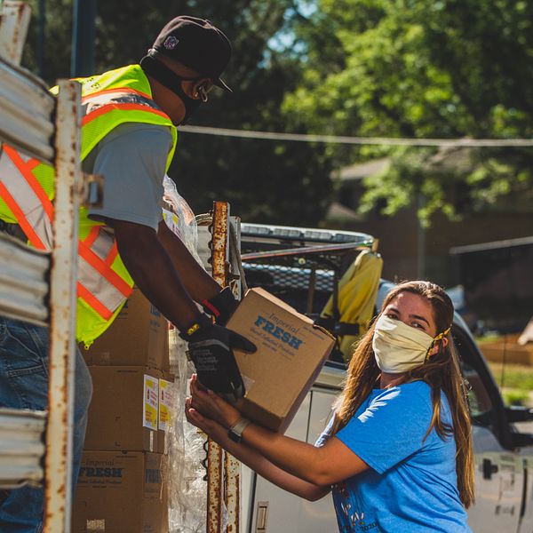 Volunteers unload PHA fresh boxes full of fruits and vegetables to promote healthy eating for families and communities in need.