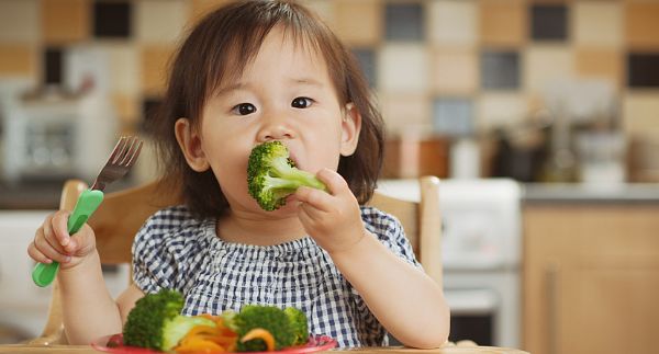 Image of toddler eating broccoli and vegetables