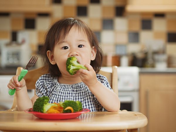 Girl eating broccoli