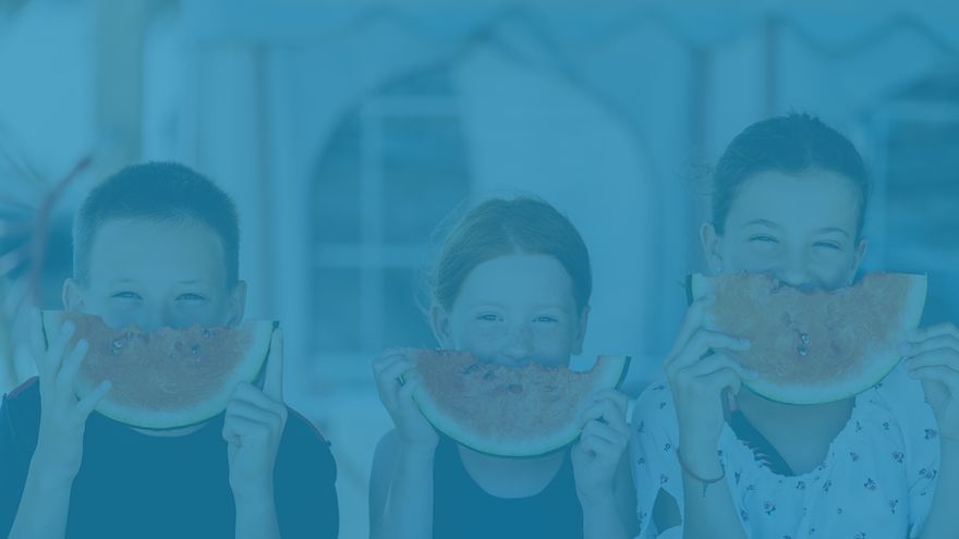 Three kids eating watermelon in the summer