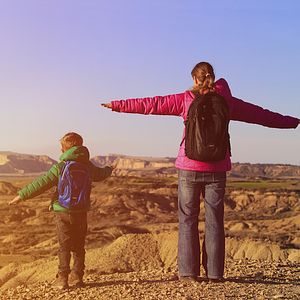 Image of a mother and child standing on top of a mountain. 