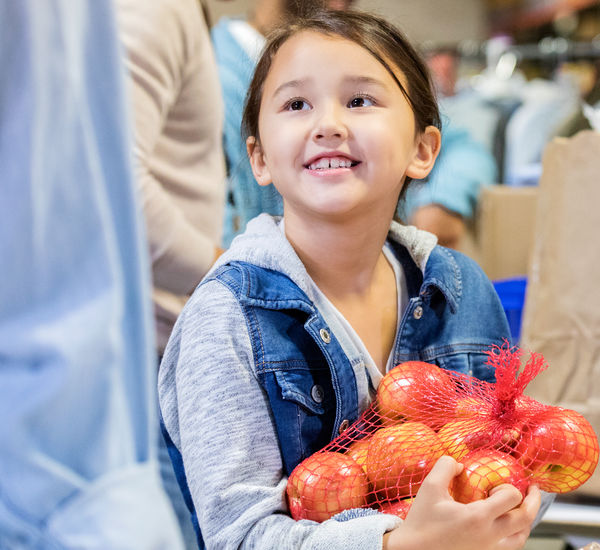 Girl with apples at food bank.