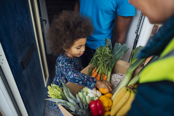 Child looking at a box of produce