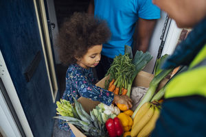 Child looking at a box of produce