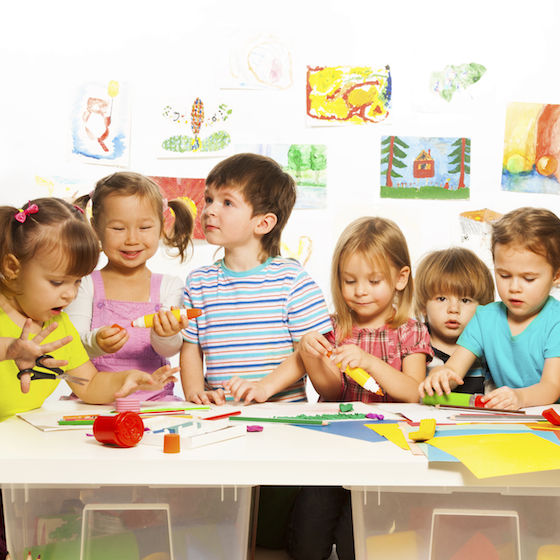 Image of preschool children at a table doing arts and crafts.