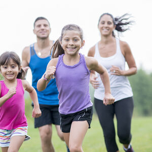 Image of a family of two young girls racing across a field.