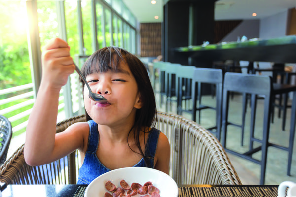 Image of a small child eating in a restaurant.