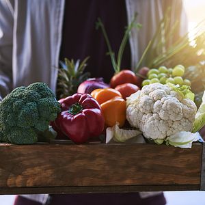 Person bringing health fruits and vegetables to children in need.