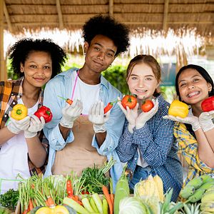 Image of teenagers smiling while holding produce