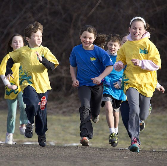 Image of children running across a field. These are participants in a children's physical activity program through BOKS.
