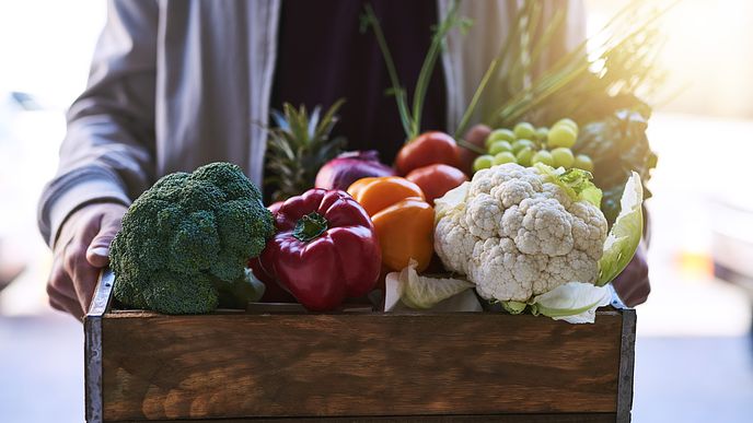 Person bringing health fruits and vegetables to children in need.