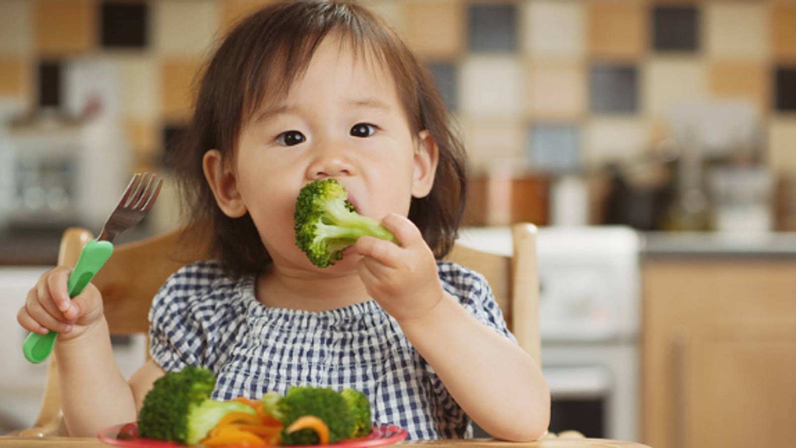 Image of toddler eating broccoli and vegetables