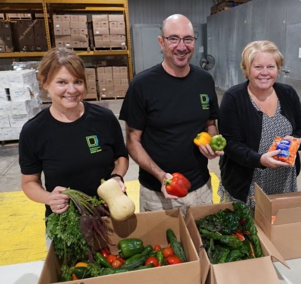 Food bank staff and volunteers opening up a box of vegetables