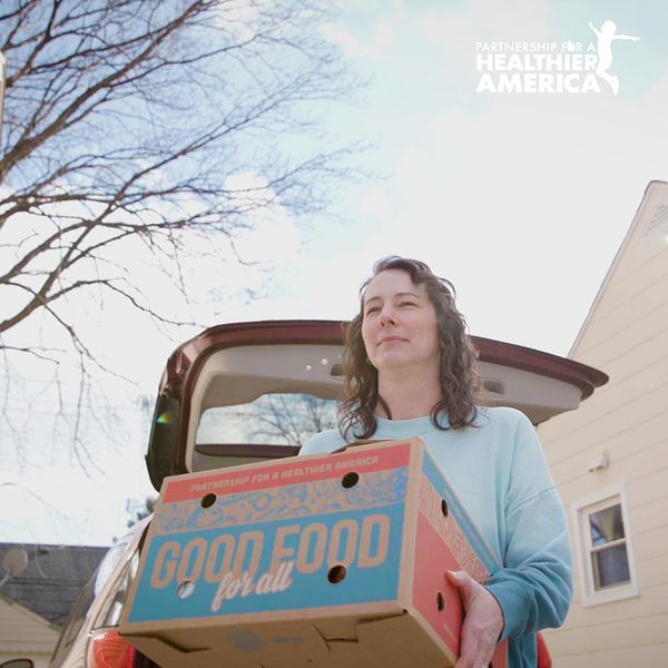 Joanna from Detroit, MI holding a Good Food for All produce box